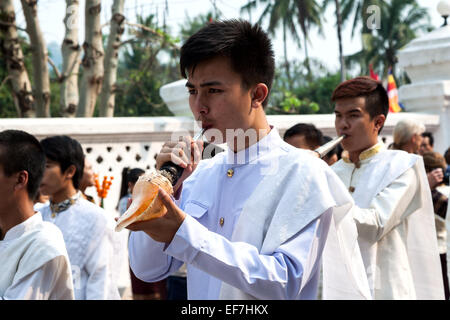 Un jeune homme soufflant dans la coquille de conque à Luang Prabang Lao Mai Rp pendant la Parade du Nouvel An. Banque D'Images