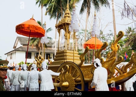 Acolytes bouddhiste poussant le chariot d'or en procession le Mue Nau, Nouvel An Lao à Luang Prabang, Laos. Banque D'Images