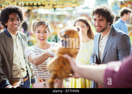 Cheerful woman reaching for soft toy en jeux électroniques Banque D'Images