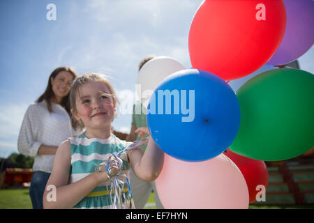 Young Girl holding bouquet de ballons colorés à sunny day Banque D'Images