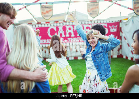 Cheerful woman celebrating victory en jeu dans un parc d'attractions Banque D'Images