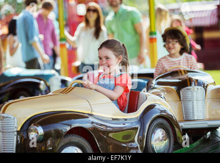 Cheerful girl sur carrousel en amusement park Banque D'Images