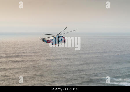 Hélicoptère de sauvetage de la Marine royale d'effectuer sauvetage réussi à Droskyn Point, Broad Oak, Cornwall, Angleterre - EDITORIAL UTILISEZ UNIQUEMENT Banque D'Images