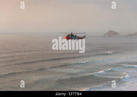 Hélicoptère de sauvetage de la Marine royale d'effectuer sauvetage réussi à Droskyn Point, Broad Oak, Cornwall, Angleterre - EDITORIAL UTILISEZ UNIQUEMENT Banque D'Images