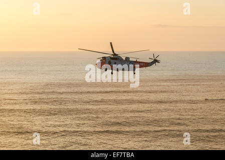 Hélicoptère de sauvetage de la Marine royale d'effectuer sauvetage réussi à Droskyn Point, Broad Oak, Cornwall, Angleterre - EDITORIAL UTILISEZ UNIQUEMENT Banque D'Images