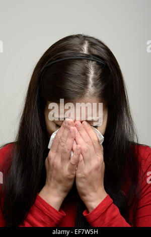 Femme de pleurer et d'essuyer ses larmes avec un mouchoir en papier Banque D'Images