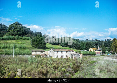 Vieille ferme abandonnée avec toit en tuile rouge vert luxuriant paysage agricole au milieu des douces collines de la campagne toscane italie Banque D'Images