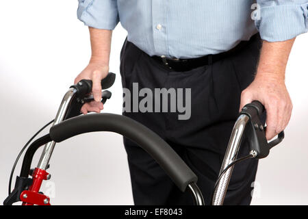 Personnes âgées handicapées l'homme est à l'aide d'une marchette pour empêcher de tomber et de lui donner de la stabilité comme il marche seul pour la vie indépendante. Banque D'Images