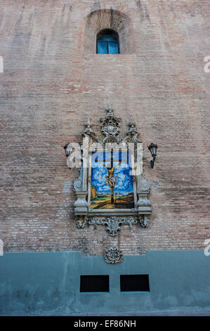 Azulejo montrant Jésus sur la croix sur un mur extérieur de l'église de l'Annonciation (Iglesia de la Anunciacion) à Séville. Banque D'Images