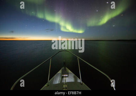 Au Canada, le Nunavut, Territoire, Aurora Borealis brille dans le ciel nocturne au-dessus de C-Dory bateau de l'expédition dans le détroit de Roes Welcome dans le nord de l'Hu Banque D'Images