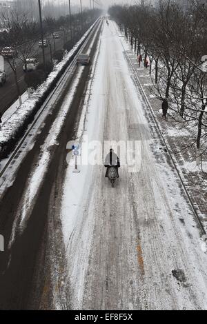 Taiyuan, la province de Shanxi. 29 janvier, 2015. Un résident des manèges d'une moto sur une route enneigée à Taiyuan, capitale du nord La province de Shanxi, le 29 janvier 2015. Une chute de neige a frappé la plupart partie de Shanxi depuis la nuit du 28 janvier. Credit : Zhan Yan/Xinhua/Alamy Live News Banque D'Images