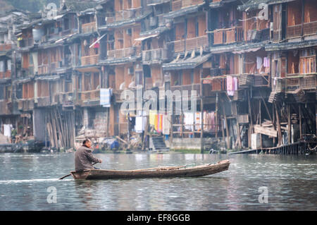L'homme local dans un bateau à rames sur la rivière Tuojiang, Fenghuang, Chine Banque D'Images
