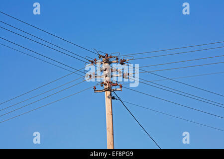 Pylône de l'électricité avec des lignes à haute tension et isolateurs contre le ciel bleu Banque D'Images