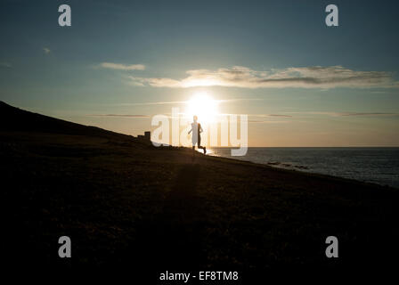 Silhouette d'homme qui court sur la plage au coucher du soleil, la Galice, Espagne Banque D'Images