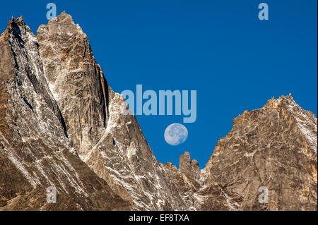 Himalaya, Kumbu, Lune visible derrière les montagnes Rocheuses dans le ciel bleu durant la journée Banque D'Images