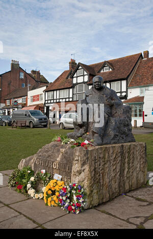 Ciel bleu sur la statue de Winston Churchill où des gerbes de fleurs ont été portées à se souvenir de sa mort il y a 50 ans Banque D'Images