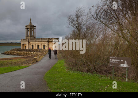 Une femme et un homme âgé à pied le long des rives de Rutland Water vers Normanton église par Rutland Water. Banque D'Images