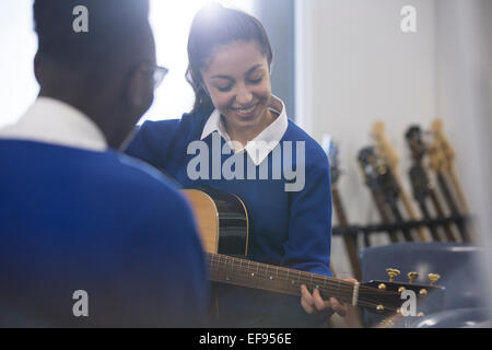 Les élèves playing acoustic guitar in classroom Banque D'Images