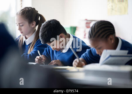 Les enfants de l'école élémentaire écrit en classe Banque D'Images