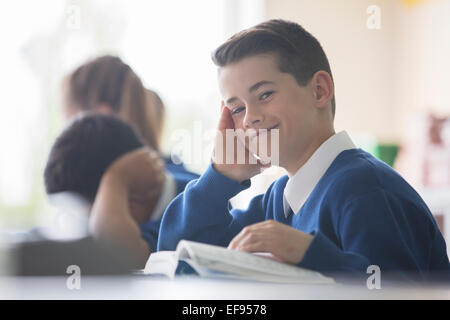 Portrait of elementary school boy sitting at desk in classroom Banque D'Images