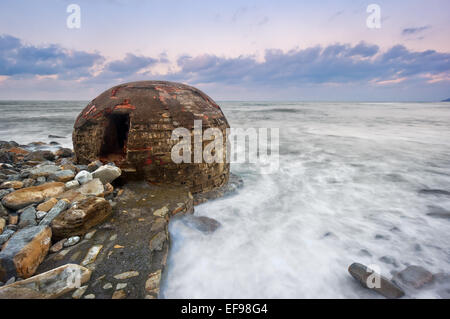 Ruines du bunker abandonné sur Azkorri plage au coucher du soleil Banque D'Images