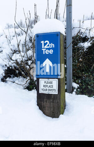 12e Tee. 'Veuillez remplacer divots' signe sur terrain de golf, dans la neige. Banque D'Images