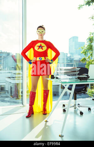 Superhero standing in office Banque D'Images