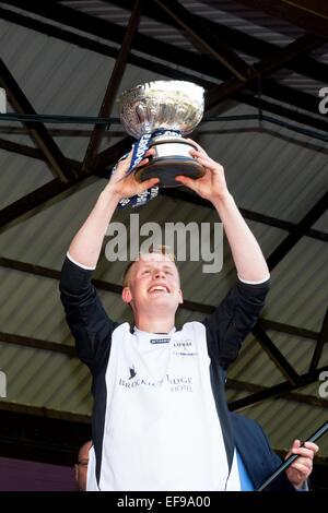 Le capitaine Lovat Callum Cruden soulève le trophée après avoir battu Glenurquhart - Co-operative MacTavish Cup 2013 Finale à Inverness. Banque D'Images