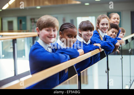 Portrait d'enfants de l'école primaire le port de l'uniforme bleu debout dans le corridor de l'école Banque D'Images
