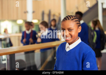 Portrait of elementary school girl wearing blue school uniform standing in school corridor Banque D'Images