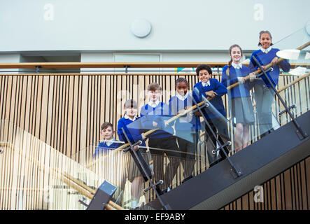 Portrait d'enfants de l'école primaire le port de l'uniforme bleu debout sur mesures dans l'école Banque D'Images