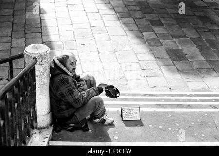 Un portrait d'un homme assis sur l'escalier dans le quartier de San Polo et de supplier pour de l'argent à Venise, Italie. Banque D'Images