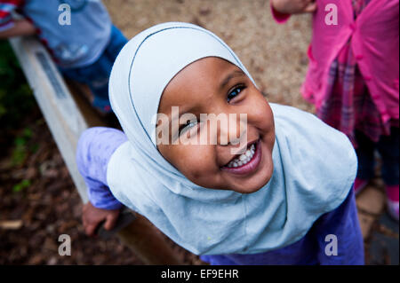 Happy Smiling fille musulmane en foulard hijab dans l'aire de jeux de l'école primaire de Londres W2 Banque D'Images