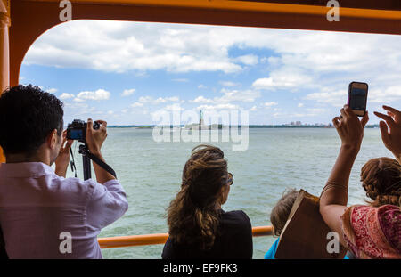 Les passagers à bord du ferry pour Staten Island pour prendre des photos de la Statue de la liberté, New York, NY, USA Banque D'Images