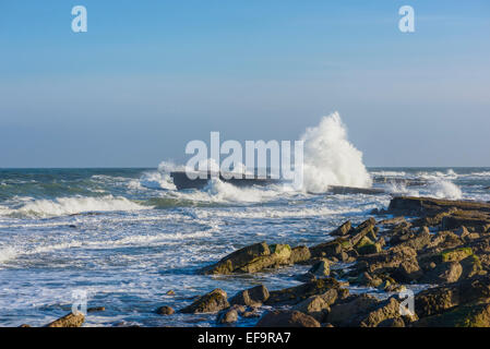 Les vagues déferlent contre une jetée dans une mer formée à Filey Brigg. Personne ne Banque D'Images