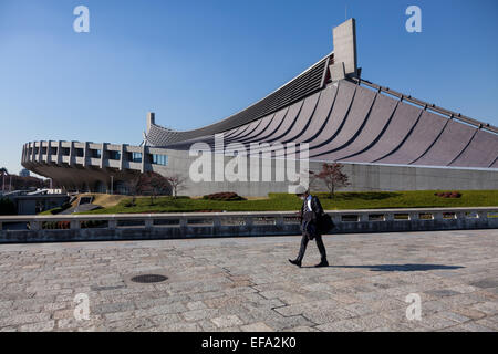 Un salaryman Japonais ou travailleur homme vérifie son portable pendant qu'il marche par la national Gymnase de Yoyogi, à Tokyo, au Japon. Banque D'Images