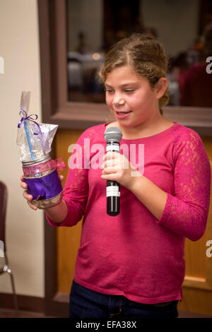 La tenue d'un microphone, d'une fille à l'Église catholique saint Timothée, Laguna Niguel, CA, est fière d'annoncer le don d'un pot de décoration des abaisse-langue numérotés à la congrégation comme une méthode de suivi des jours sur le calendrier de l'Avent. Avènement symbolise le temps de préparation de la célébration de la nativité de Jésus à Noël. Remarque Les fournitures artistiques sur table Banque D'Images