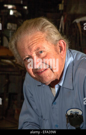 Un 82-year-old blacksmith pose fièrement dans son atelier traditionnel dans le quartier de la vieille ville de Tustin, CA. Banque D'Images