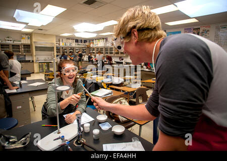 Deux étudiants en chimie avec humour duel avec les instruments de laboratoire avant le cours à San Clemente, CA. Note des lunettes de sécurité. Banque D'Images