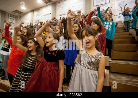 L'école intermédiaire multiracial girls geste comme ils chantent Noël dans un concert de Noël dans une école secondaire gymnase de Aliso Viejo, CA. Banque D'Images