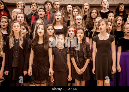 L'école intermédiaire multiraciale les enfants chantent des chants de Noël à la maison de concert qui se tiendra dans un Aliso Viejo, CA, de l'école secondaire d'un gymnase. Banque D'Images