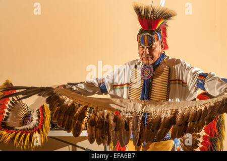 Une danseuse indienne Navajo tribal plein portant des plumes étend son costume avant d'exécuter la danse de l'Aigle traditionnel lors d'une soirée de la culture amérindienne au Laguna Niguel, CA, bibliothèque publique. Banque D'Images