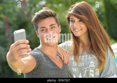 Amis adolescents faisant face sur smartphone Banque D'Images