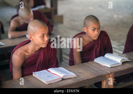 Les jeunes moines novices birmane livres d'études dans un monastère de Bagan. Banque D'Images