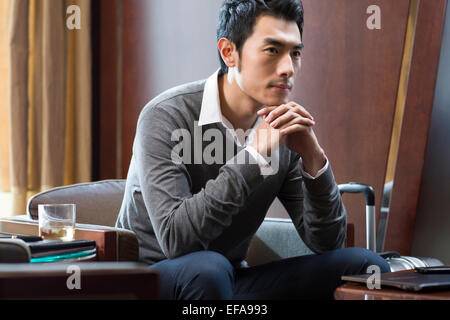 Young businessman thinking in hotel room Banque D'Images