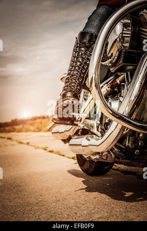 Biker girl riding sur une moto. Vue du bas des jambes dans des bottes de cuir. Banque D'Images