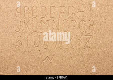 Anglais, Allemand, Portugais alphabet écrit sur le sable, en arrière-plan Banque D'Images