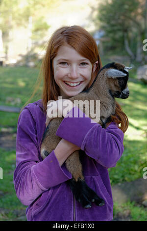 Girl holding a chèvres naines dans le zoo pour enfants à Schopperalm Gießenbachklamm, Schopper, Alm, à proximité Ebbs, vallée de l'Inn Banque D'Images