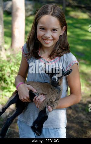 Girl holding a chèvres naines dans le zoo pour enfants à Schopperalm Gießenbachklamm, Schopper, Alm, à proximité Ebbs, vallée de l'Inn Banque D'Images