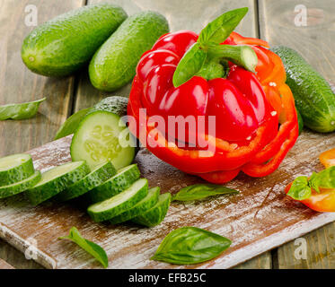 Paprika rouge et des concombres sur une table en bois Banque D'Images